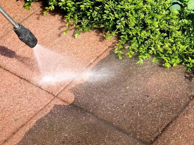 Pressure washing a paved path edge in Sydney